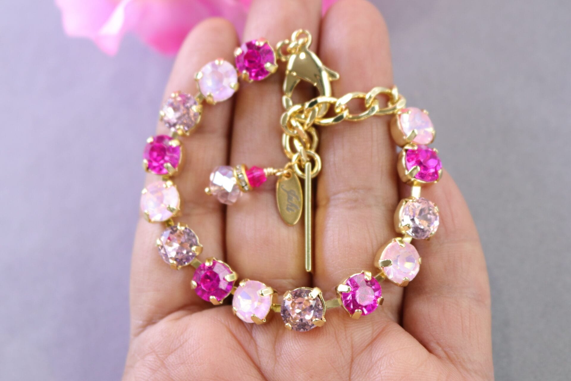 Pink crystal tennis bracelet in gold or silver with hot pink, blush, and opal pink stones.