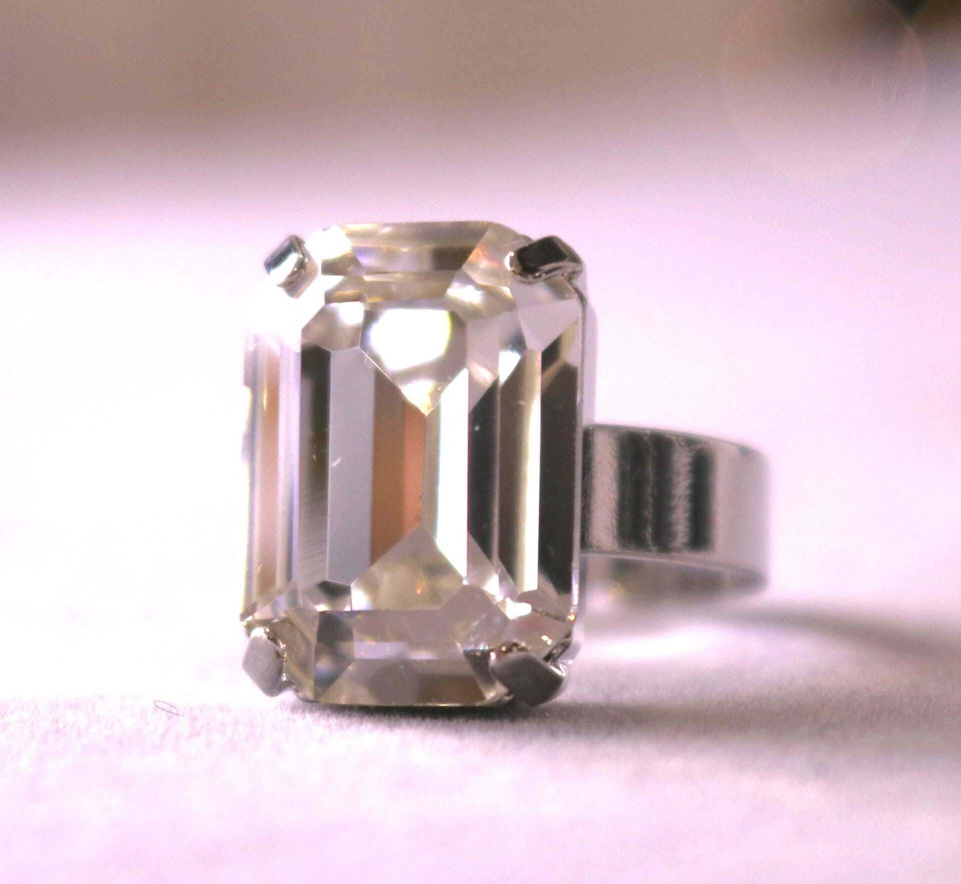Emerald-cut clear Austrian crystal ring with diamond-like sparkle. Adjustable gold or silver band.