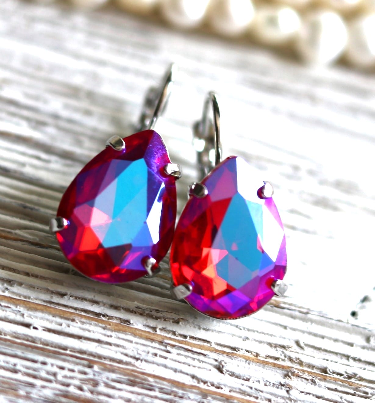 Bold teardrop earrings with vibrant pink, red & violet-blue crystals. Available in silver or gold finishes — statement jewelry for weddings & parties.